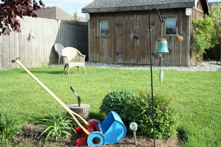 Songbird perched on a shepherds hook bird feeder in a cottage garden